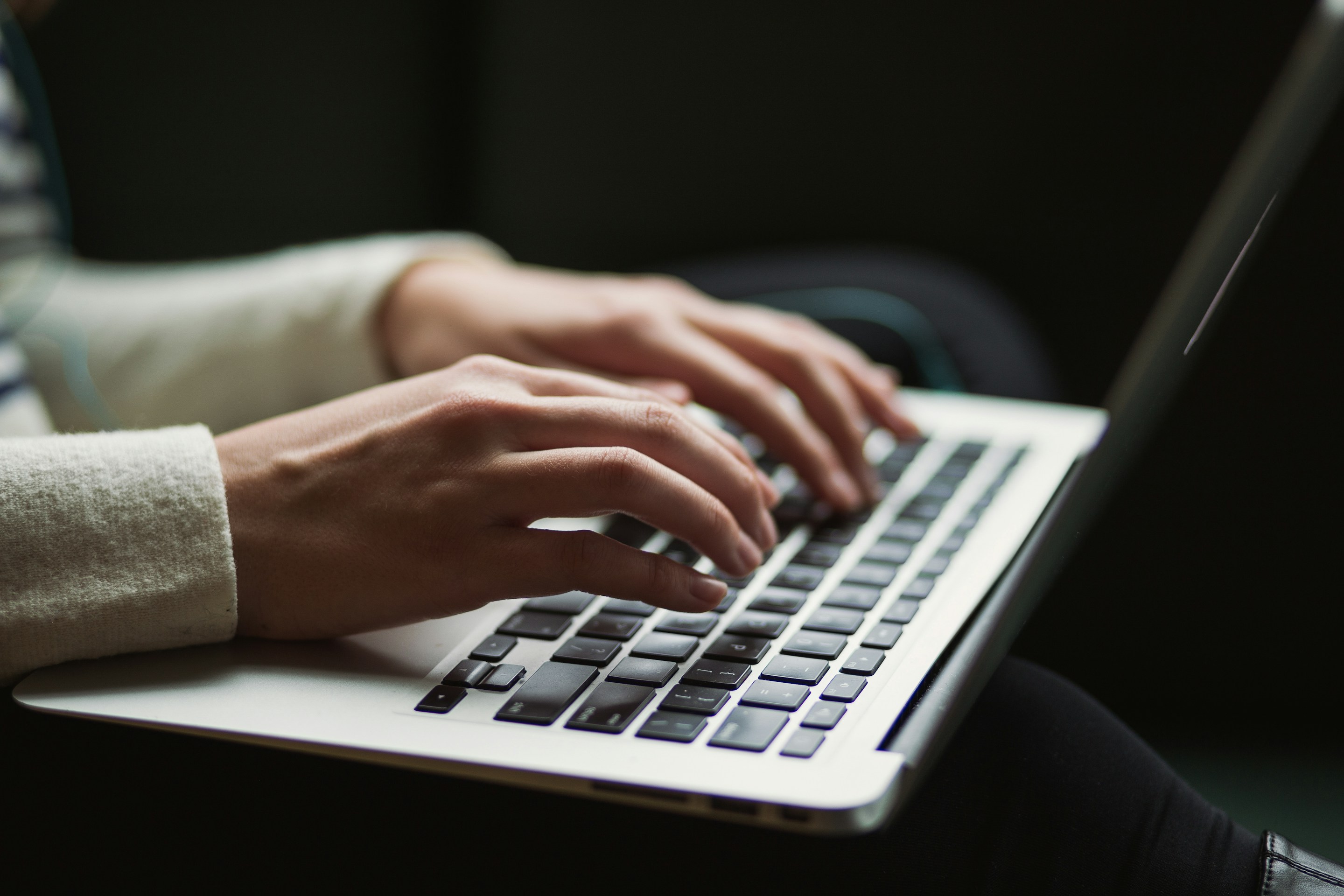 Hands typing on laptop